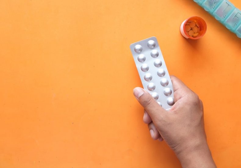 person holding white blister pack